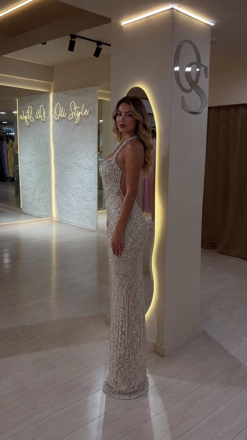 Side profile of woman wearing champagne embellished halter neck maxi formal dress