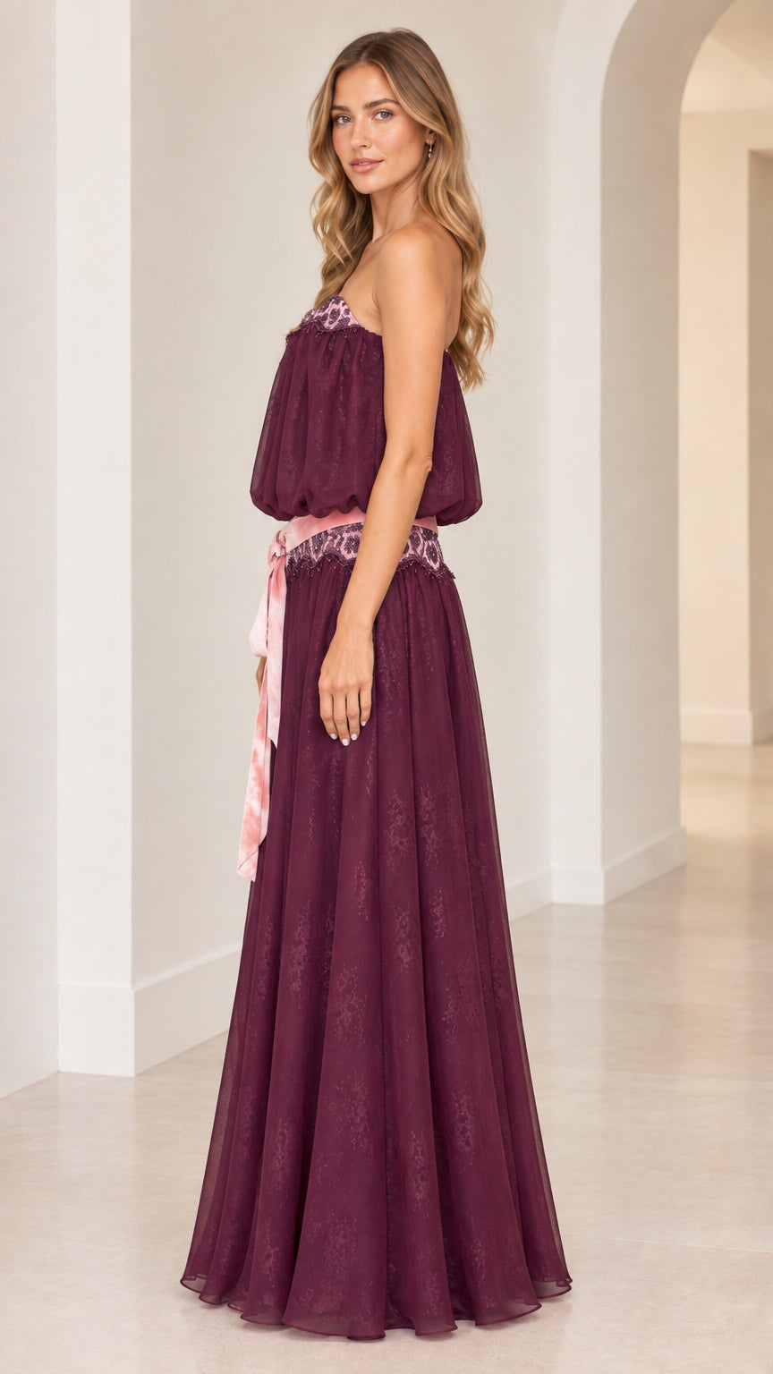 Side profile of woman in strapless plum purple blouson maxi dress