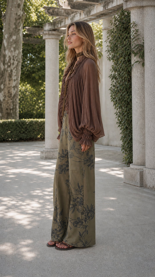 Model side profile in boho balloon sleeve blouse and olive floral wide-leg pants