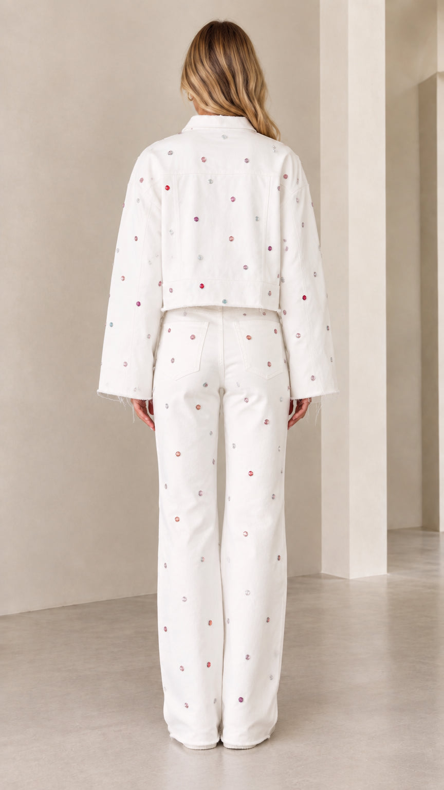Back view of woman wearing white embellished cropped jacket and wide-leg trousers