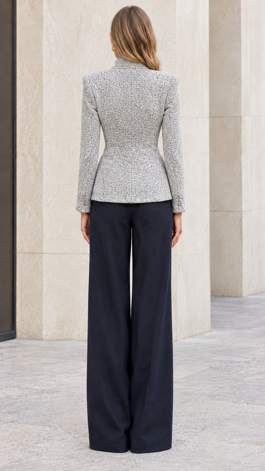 Back view of model showing tailored hourglass silhouette of grey tweed jacket