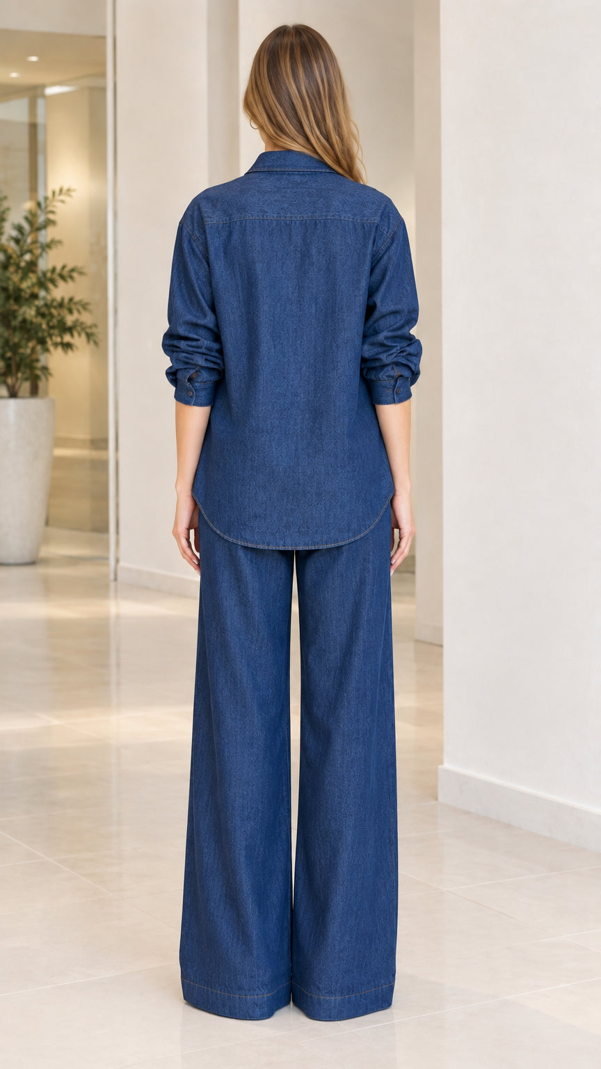 Back view of women's denim blue relaxed button-down shirt and wide-leg pants