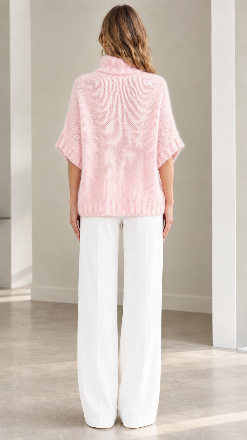 Back view of model wearing Light Pink fluffy short sleeve poncho sweater