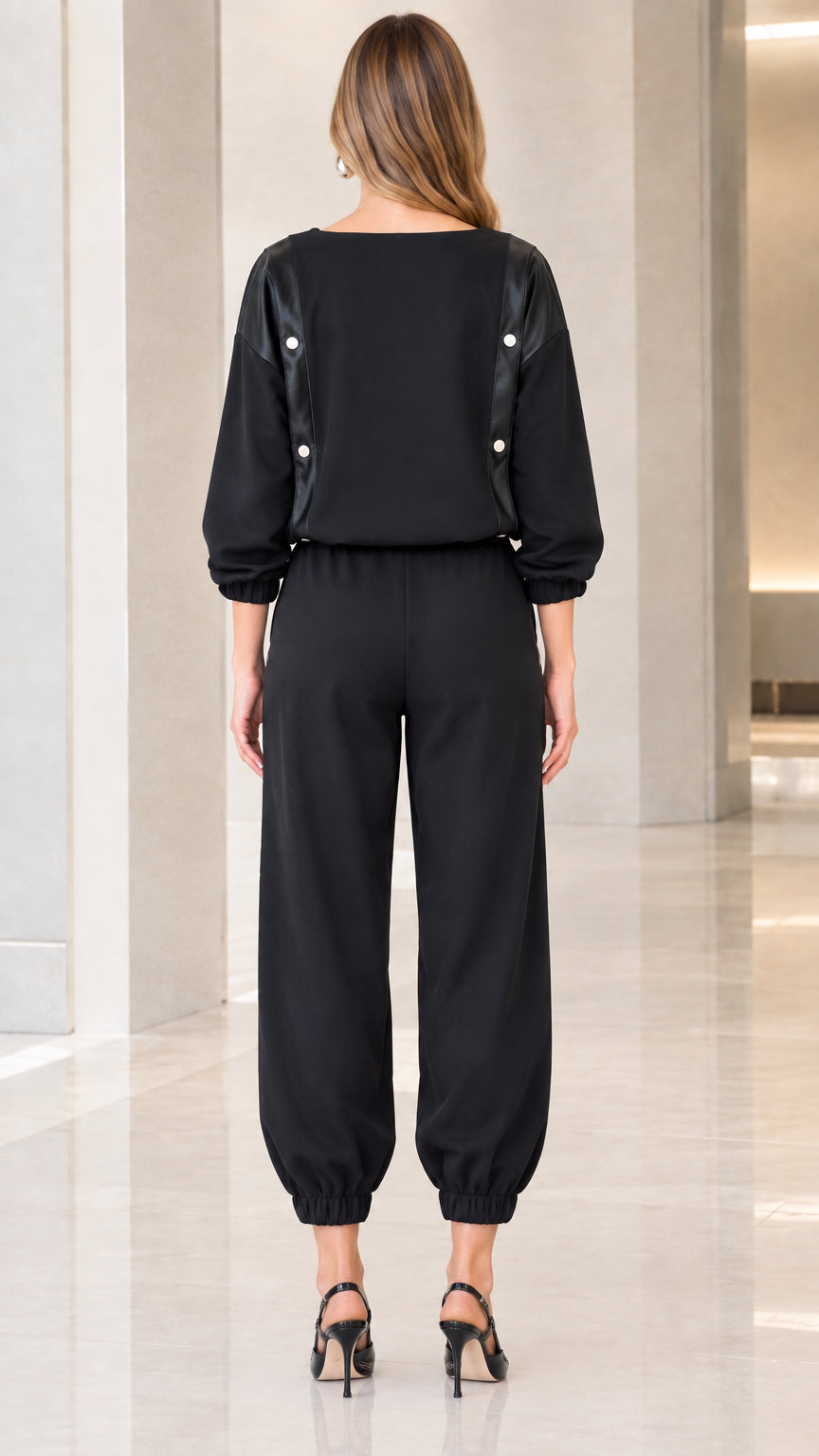 Back view of women's black two-piece jogger set with shoulder snap details
