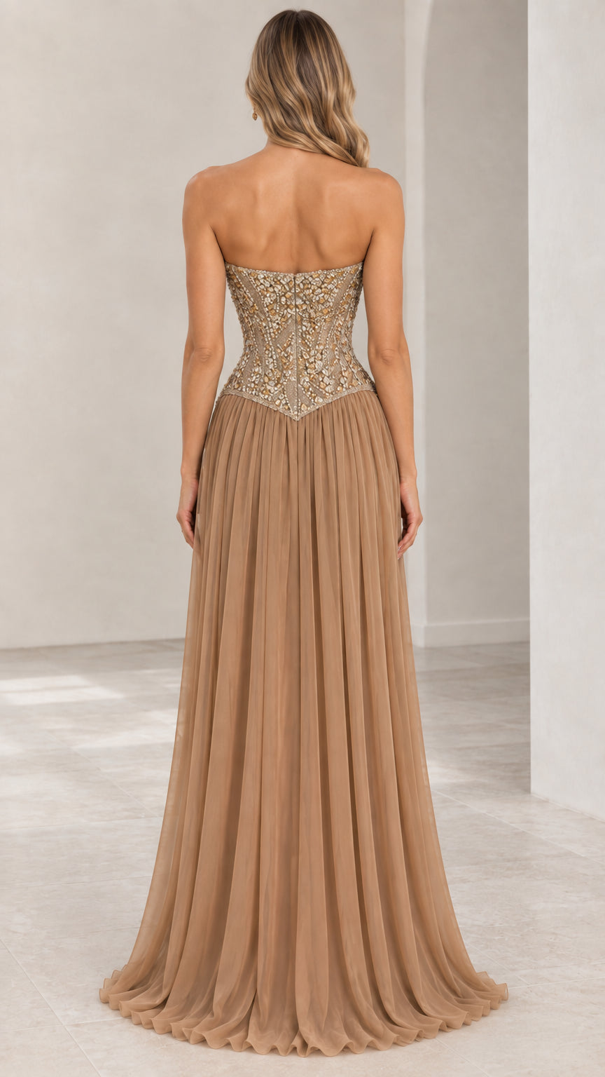 Back view of champagne strapless evening gown showing fitted beaded bodice and pleated skirt