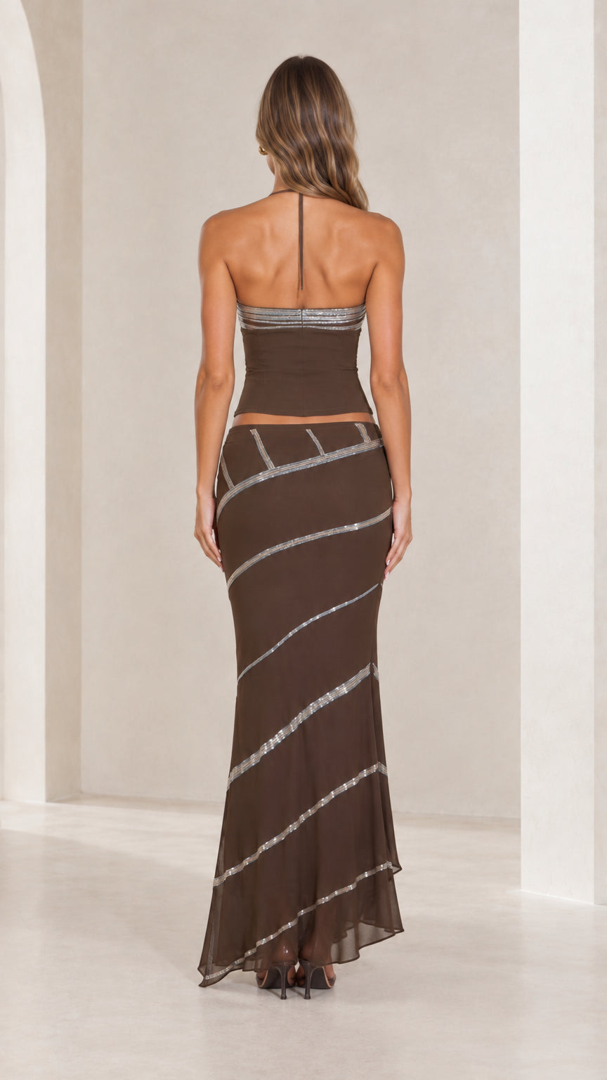 Back view of chocolate brown halter neck crop top and low-rise maxi skirt set