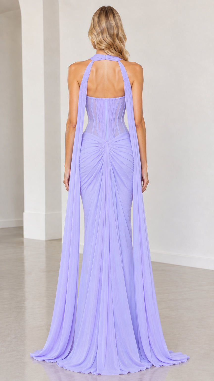 Back view of model wearing lavender corset maxi gown with sweeping cape streamers