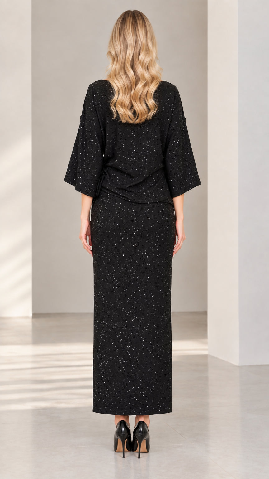 Back view of woman wearing elegant black shimmer long skirt and blouse set