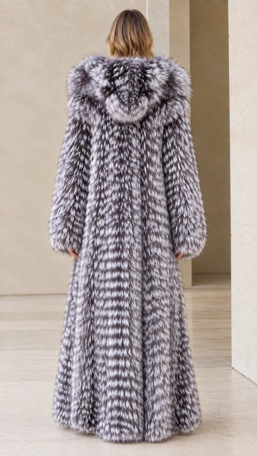 Back view of woman wearing floor-length silver grey hooded faux fur coat
