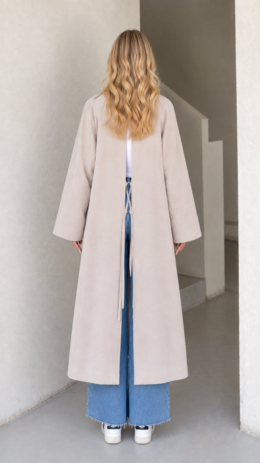Back view of model showing open back vent with adjustable tie fastening on Light Grey duster coat