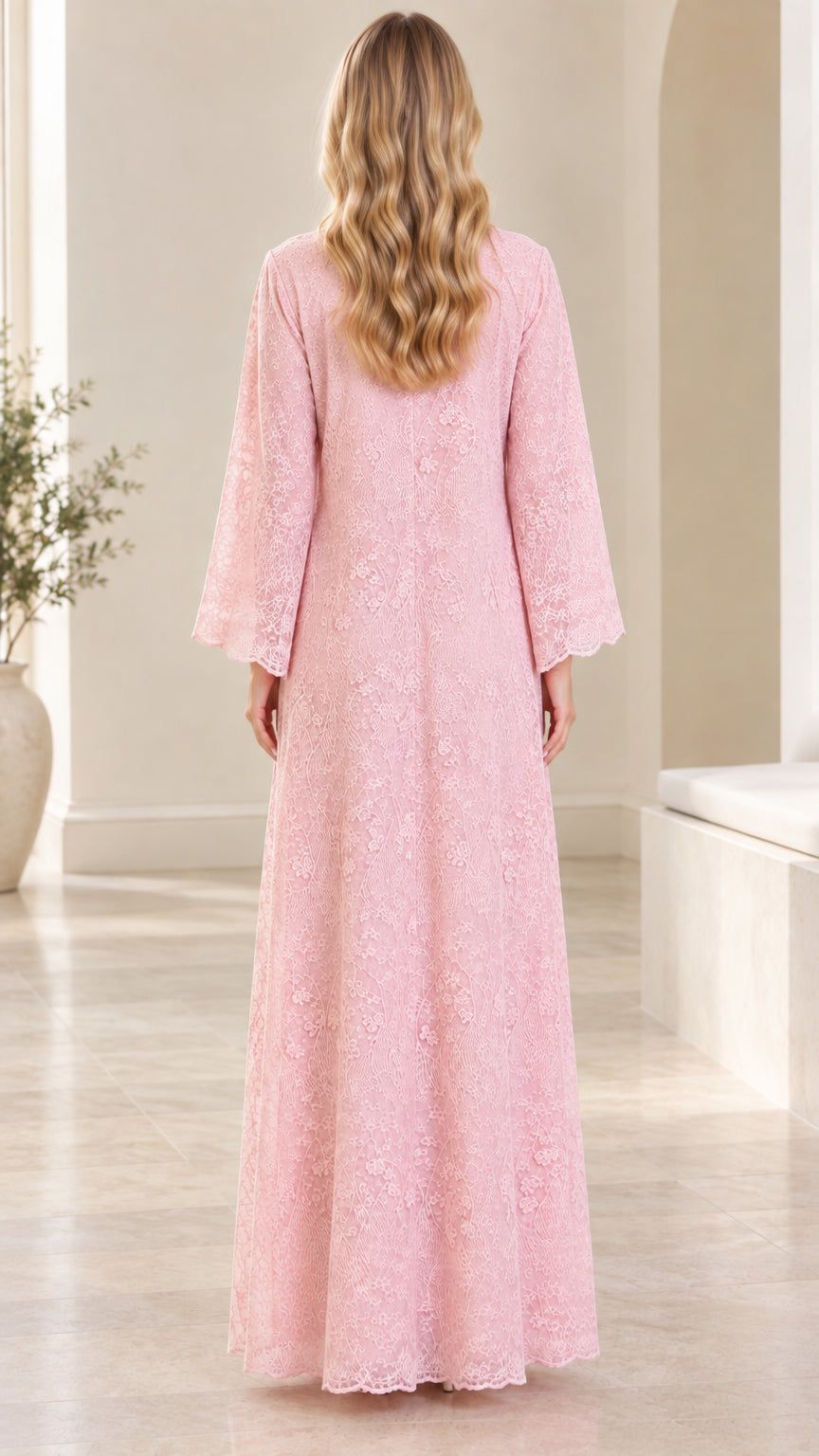 Back view of woman in flowing pink floral lace maxi gown