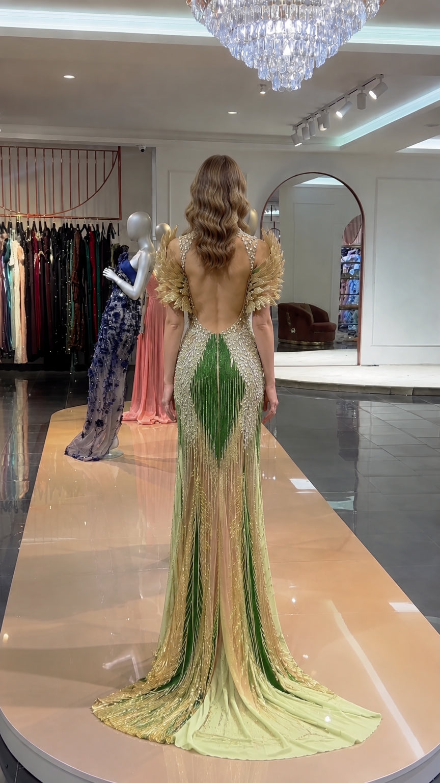 Back view of emerald green beaded evening gown showing open back and sweeping train