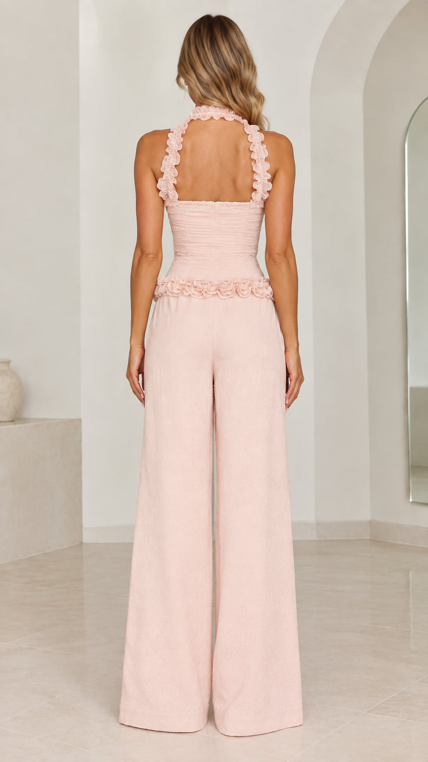 Back view of model in Blush Pink ruffle halter wide-leg jumpsuit