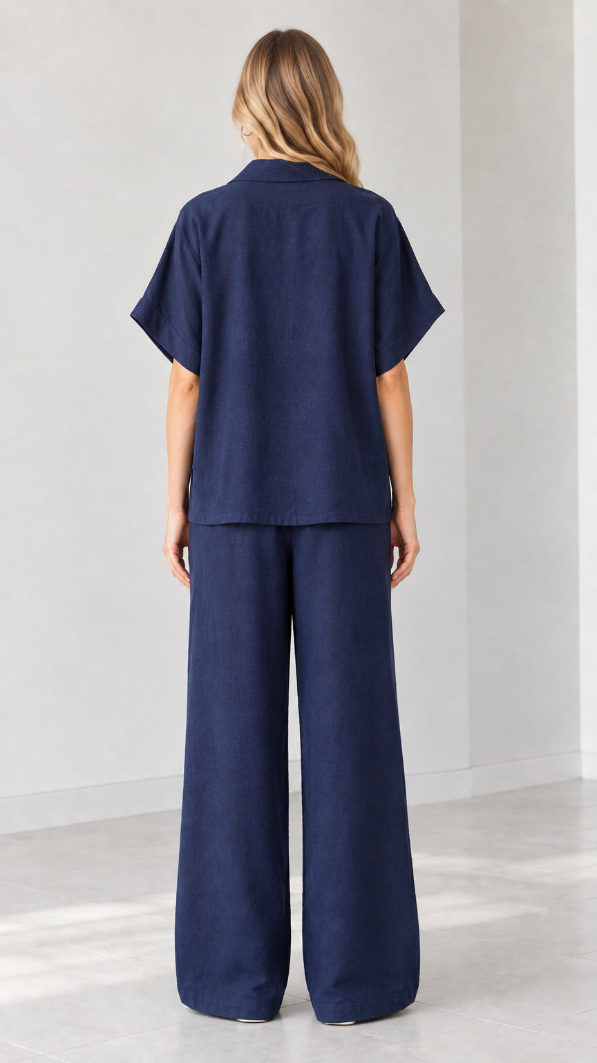 Back view of model in Navy Blue relaxed-fit button-down top and wide-leg trousers
