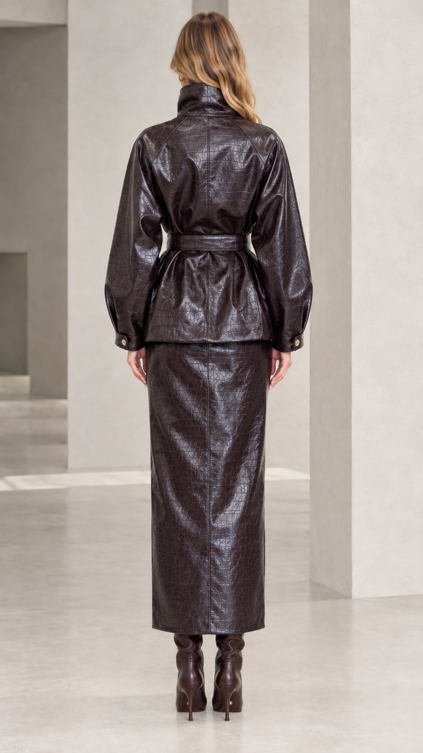 Back view of woman wearing Dark Brown croc-embossed faux leather jacket and maxi skirt
