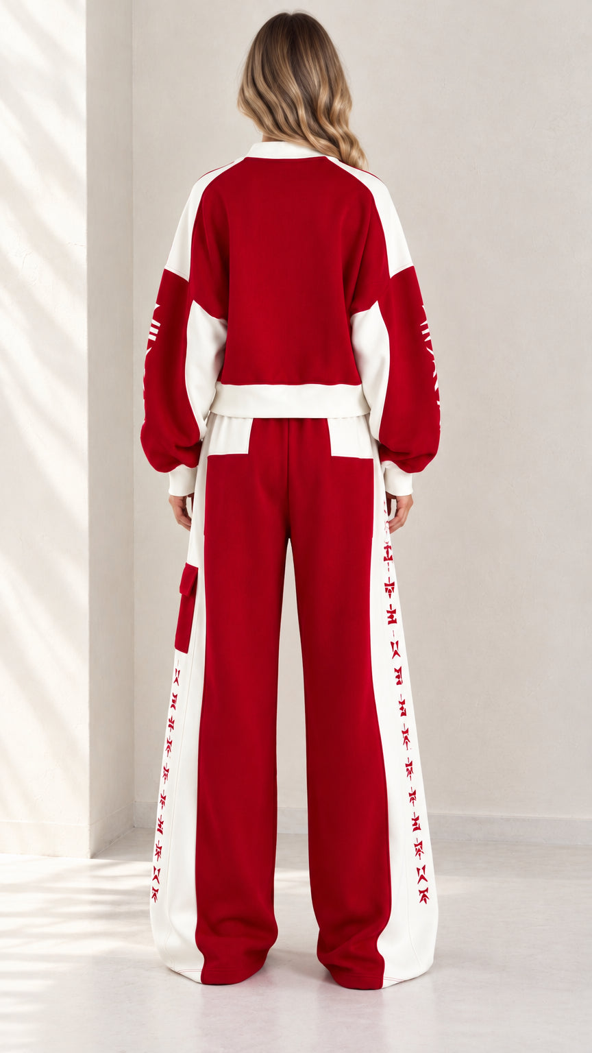 Back view of model wearing red two-piece colorblock zip jacket and sweatpants