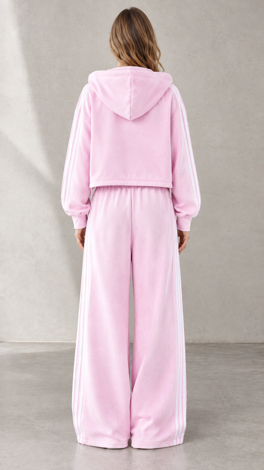 Back view of woman wearing Light Pink hooded sweatshirt and wide-leg pants
