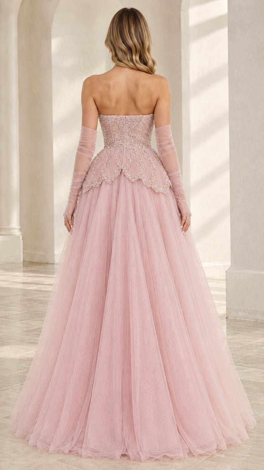 Back view of Blush Pink strapless gown with fitted bodice and flowing tulle skirt
