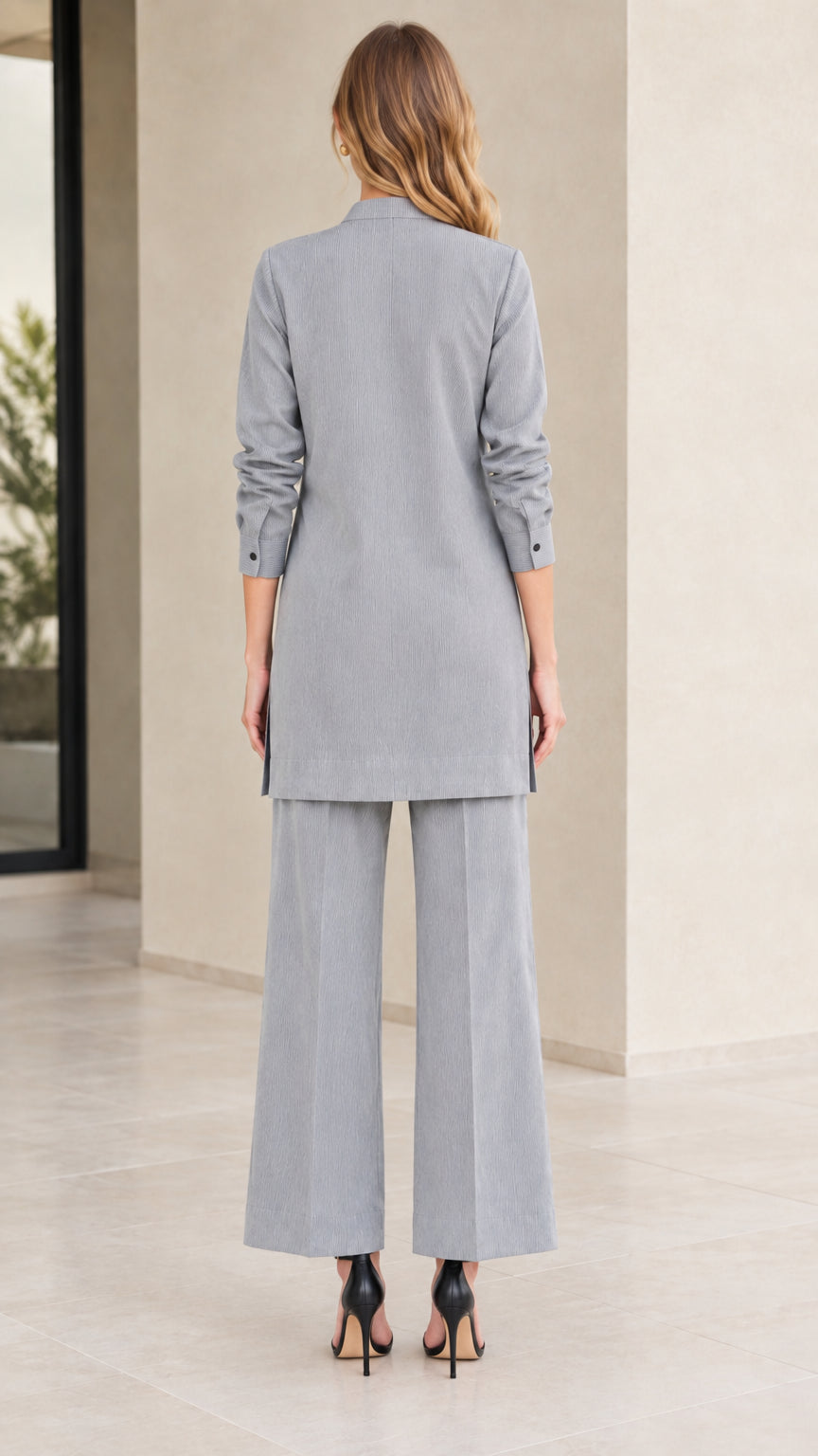 Back full-length view of woman in Light Grey longline tunic and wide leg trousers