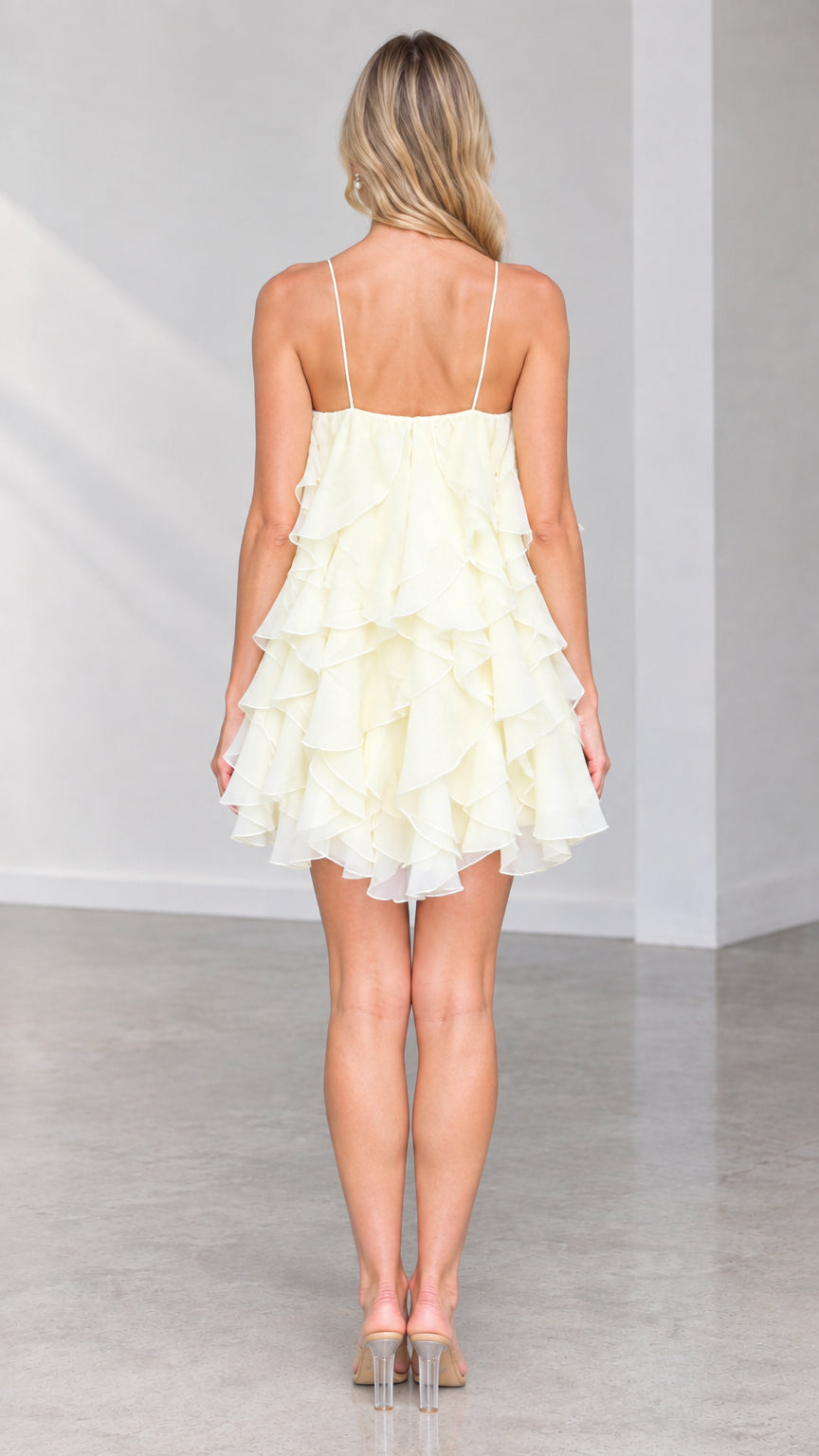 Back view of model showing strappy back and layered ruffles on Butter Yellow mini dress