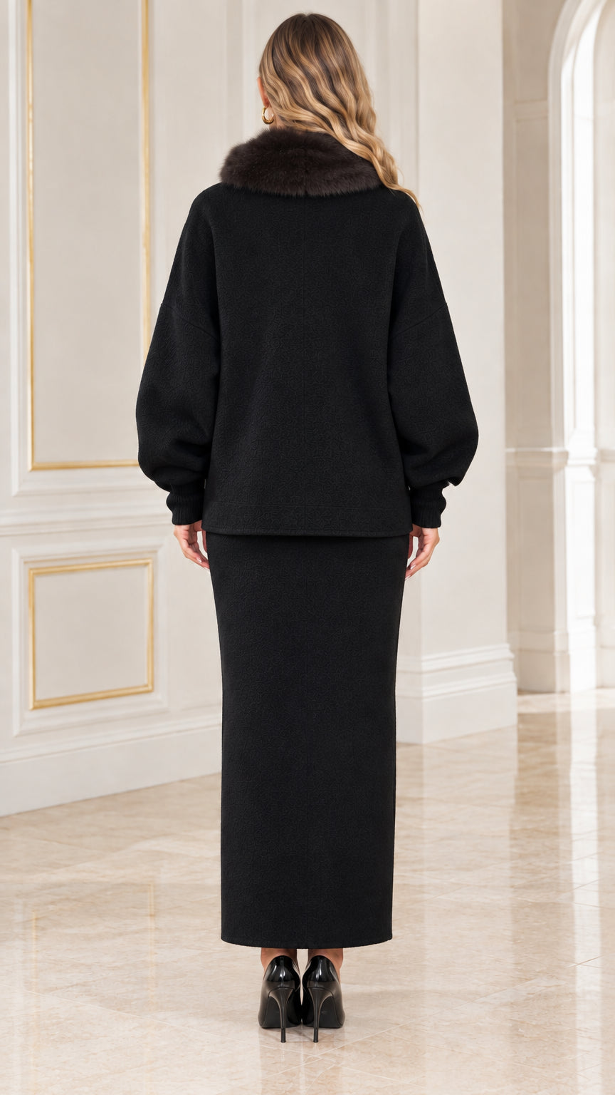 Back view of model wearing black cardigan jacket and maxi column skirt