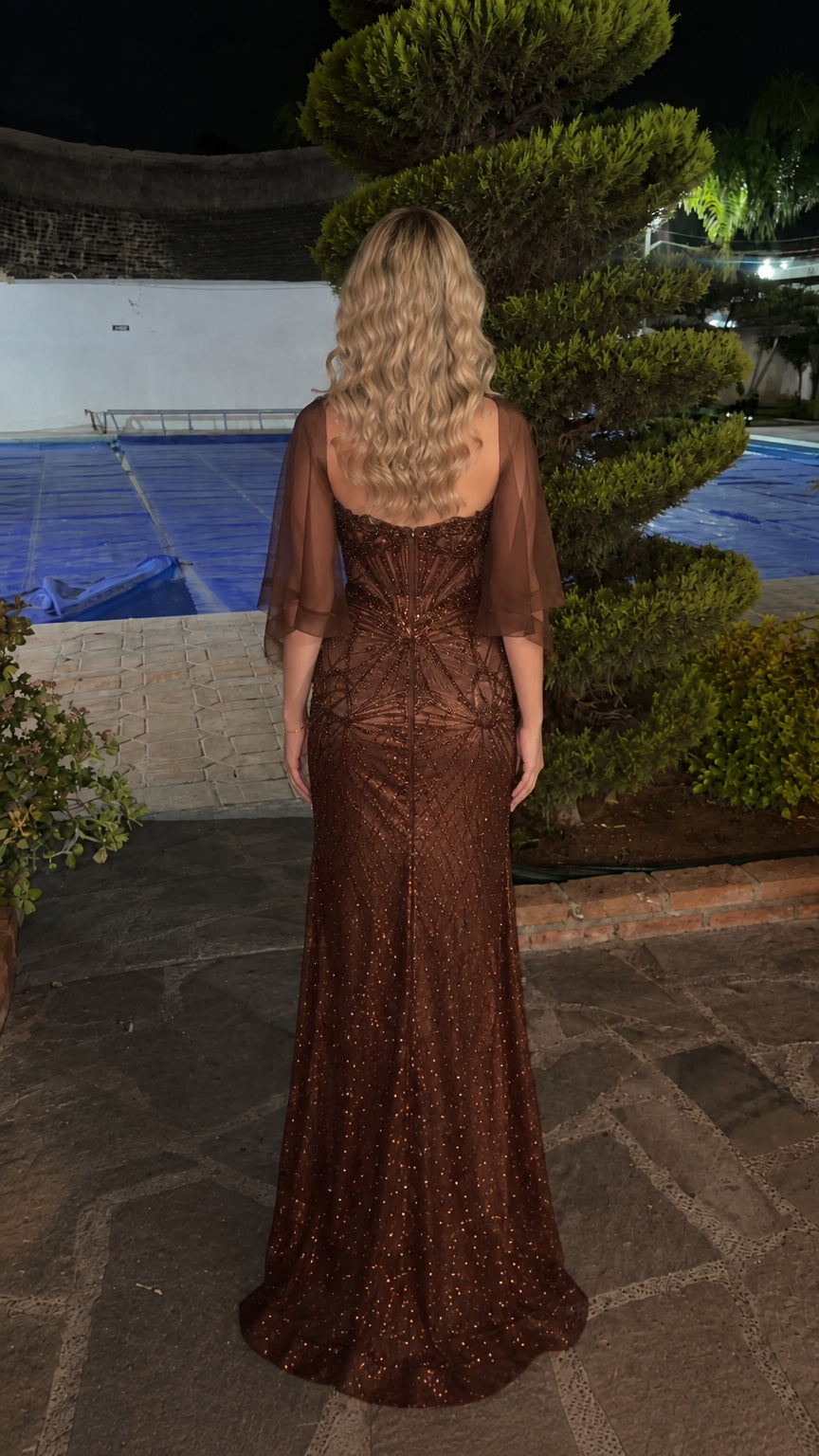 Back view of woman wearing brown beaded evening dress with matching sheer wrap