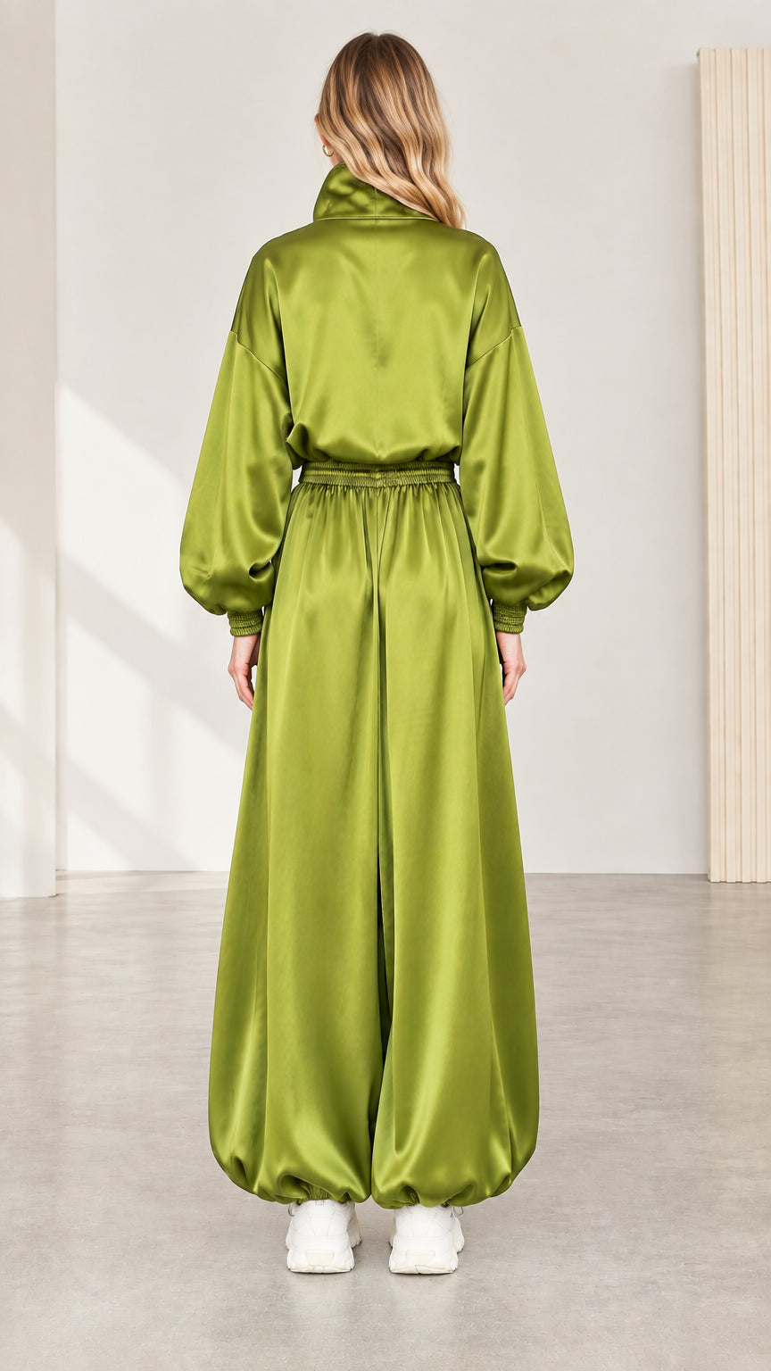 Back view of model wearing olive green satin relaxed jumpsuit with gathered ankles