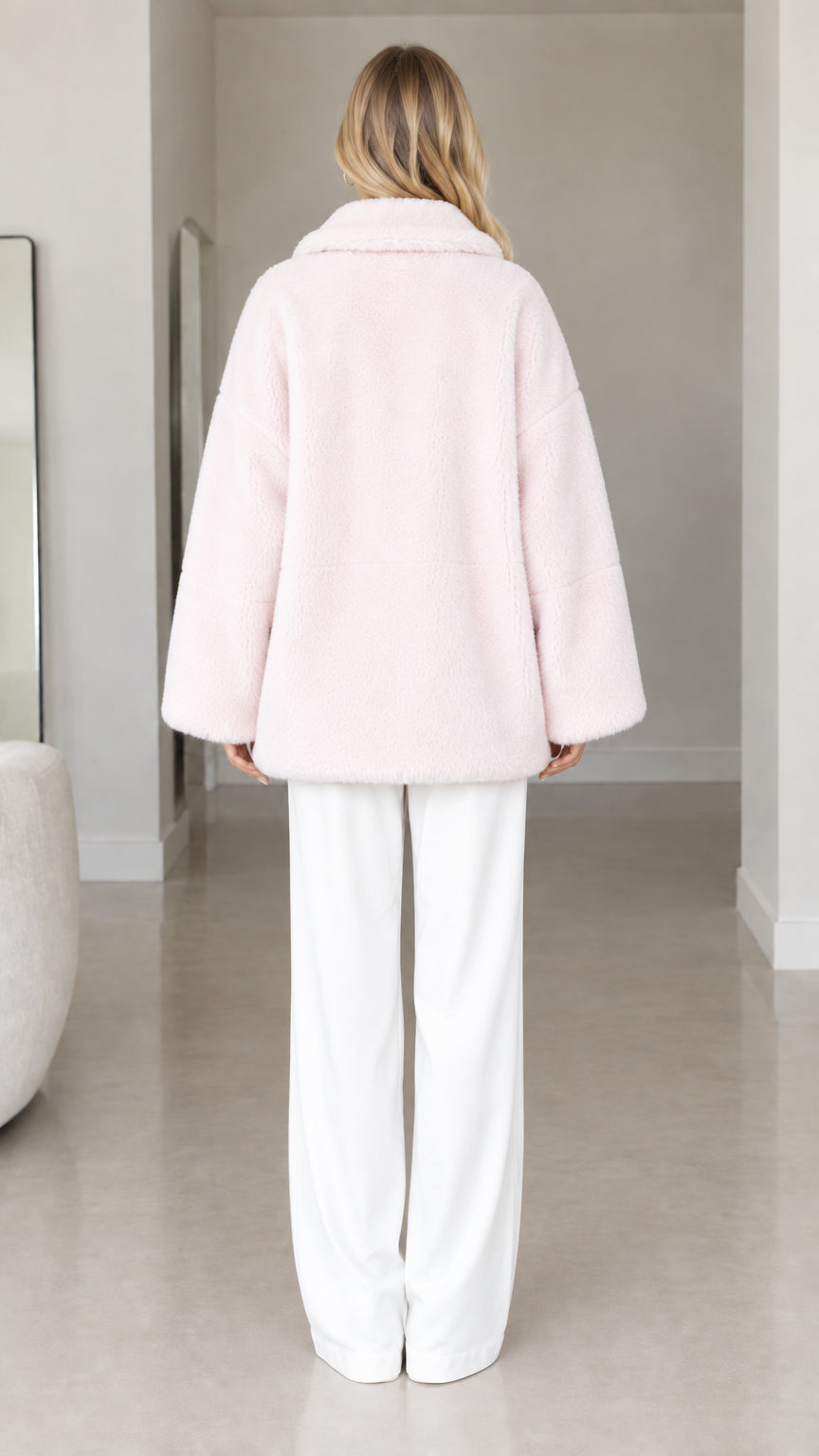 Back view of model wearing pale pink relaxed fit faux fur coat