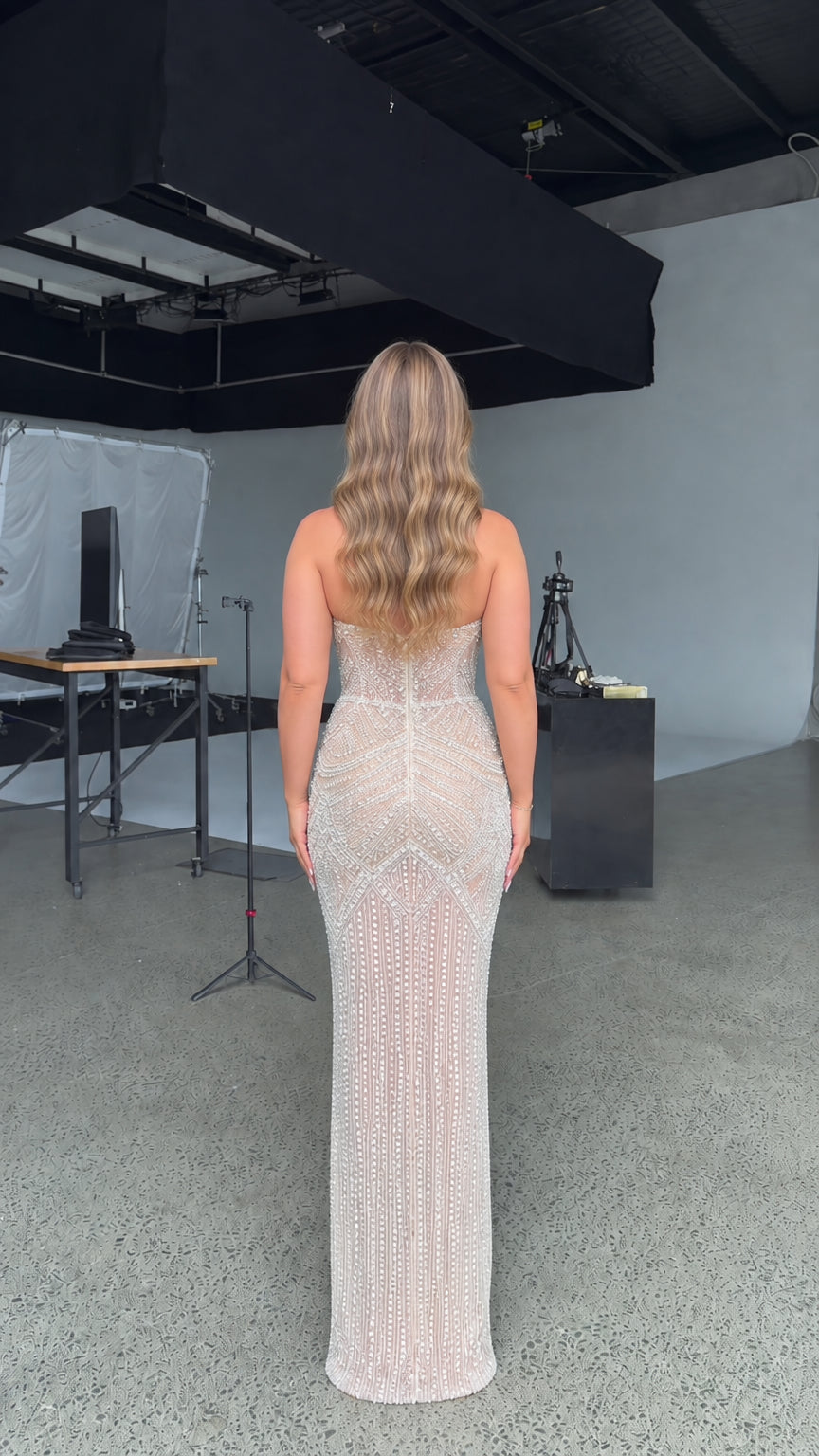 Back view of model in fitted champagne strapless evening gown