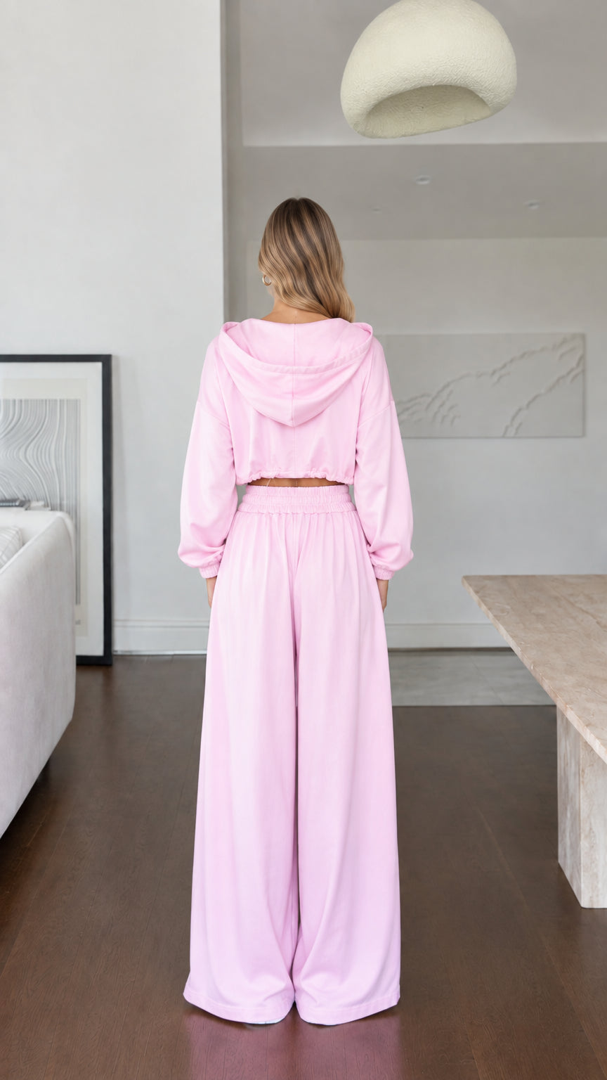 Back view of model wearing pink hooded lounge jacket and wide pants