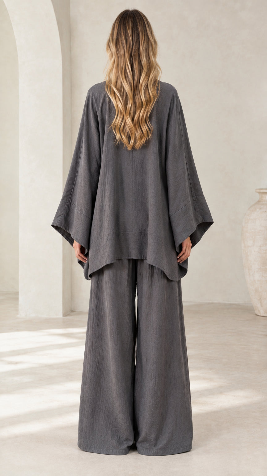 Back view of women's charcoal gray loose fit tunic top and relaxed wide leg trousers