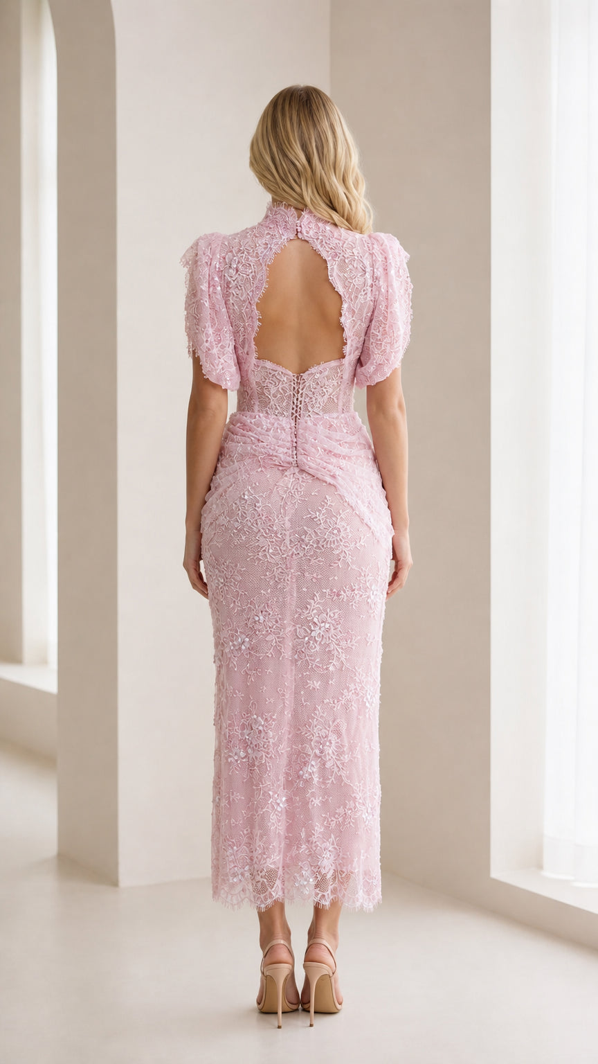 Back view of model showing open back detail of pink lace dress