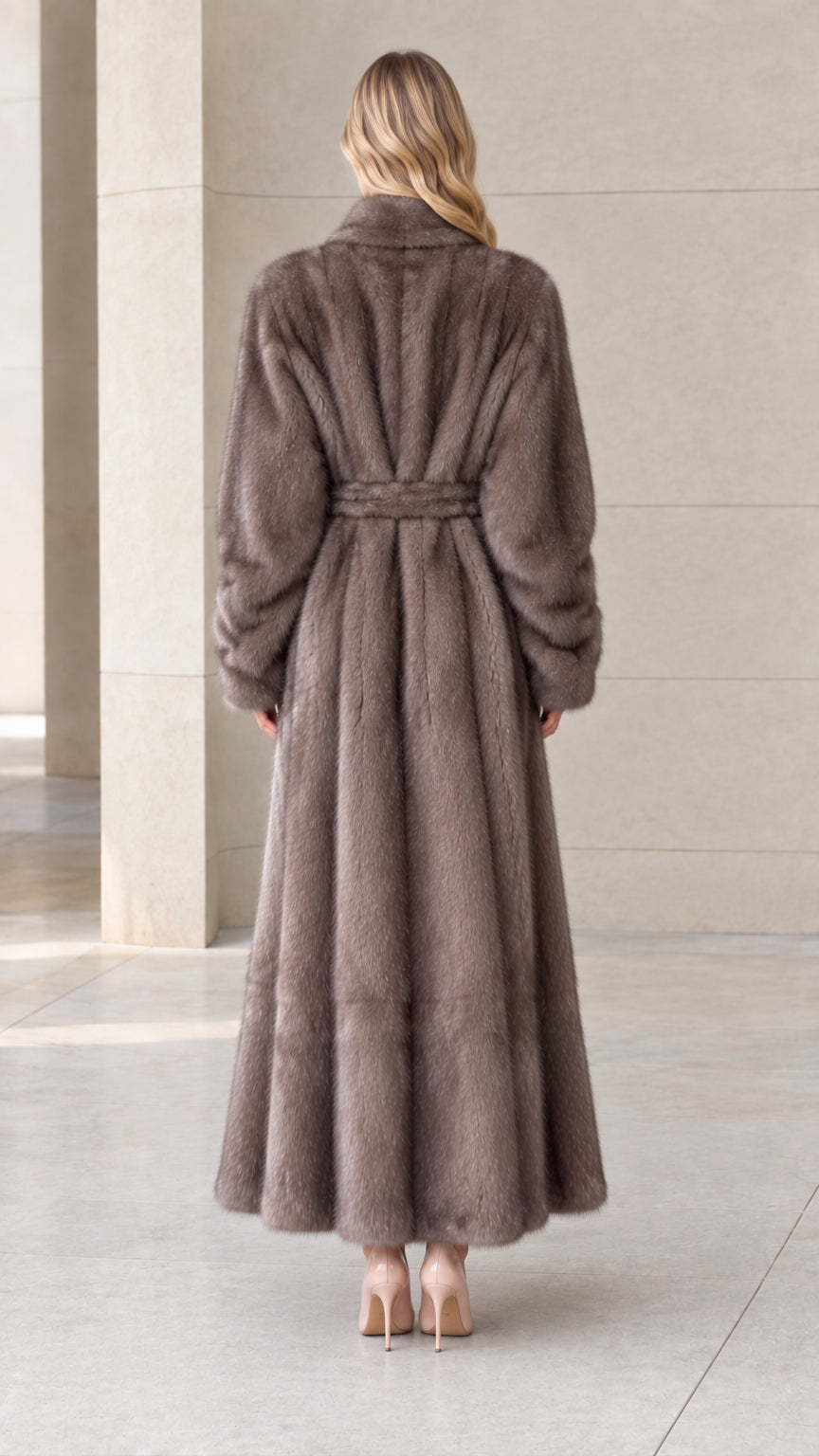 Back view of woman wearing long taupe plush coat with belted waist