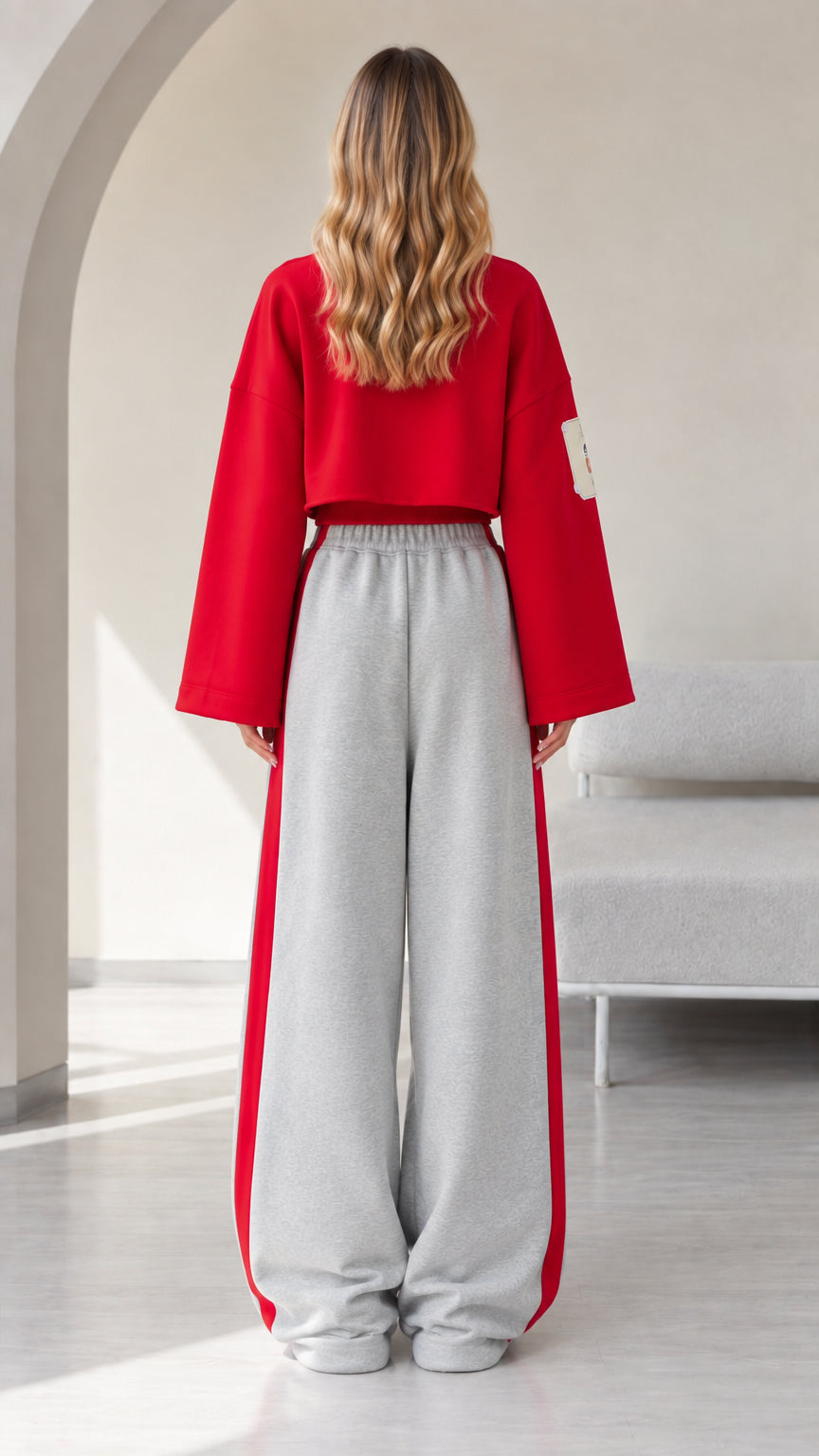 Back view of model in red cropped sweatshirt and matching grey wide leg sweatpants