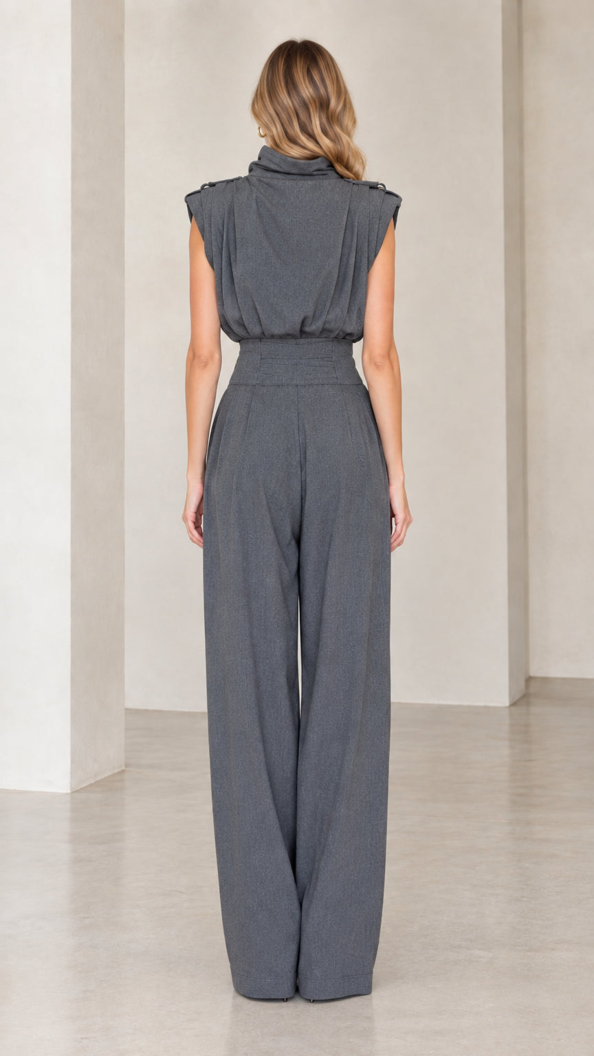 Back view of woman wearing charcoal grey draped sleeveless jumpsuit
