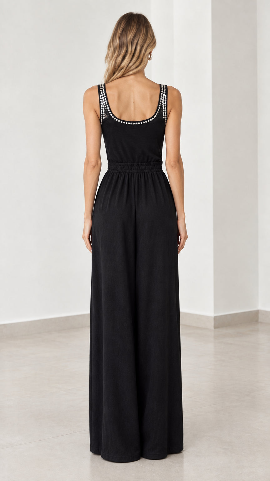 Back view of model wearing black scoop back wide leg jumpsuit