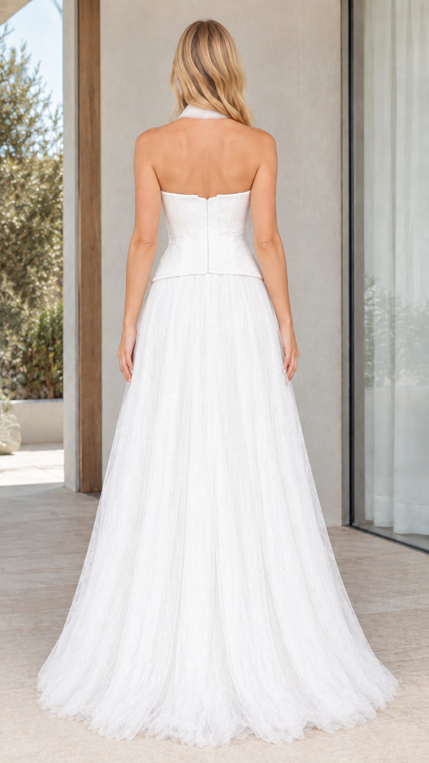 Back view of strapless white gown showcasing zipper and flowing tulle skirt