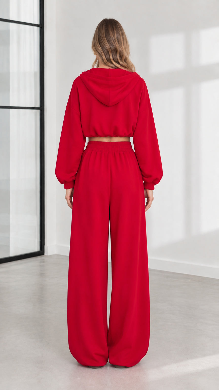 Back view of model wearing red hooded sweatshirt and relaxed sweatpants