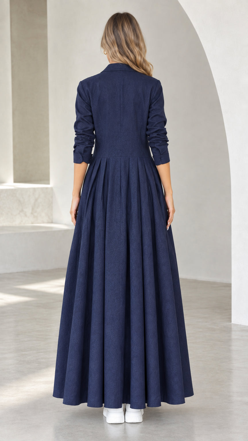 Back view of model showing pleated skirt drape on Navy Blue maxi coat