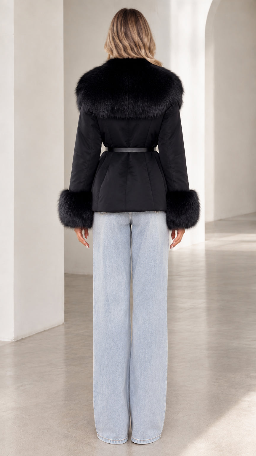 Back view of model wearing black belted jacket with wide faux fur collar