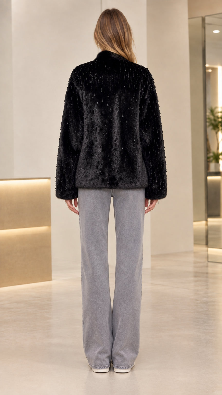 Back view of model wearing black hip-length faux fur coat