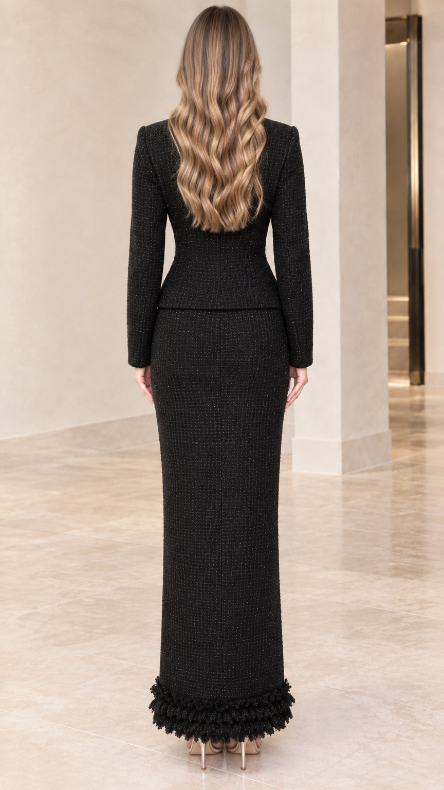 Back view of model in black tailored tweed two-piece maxi suit set