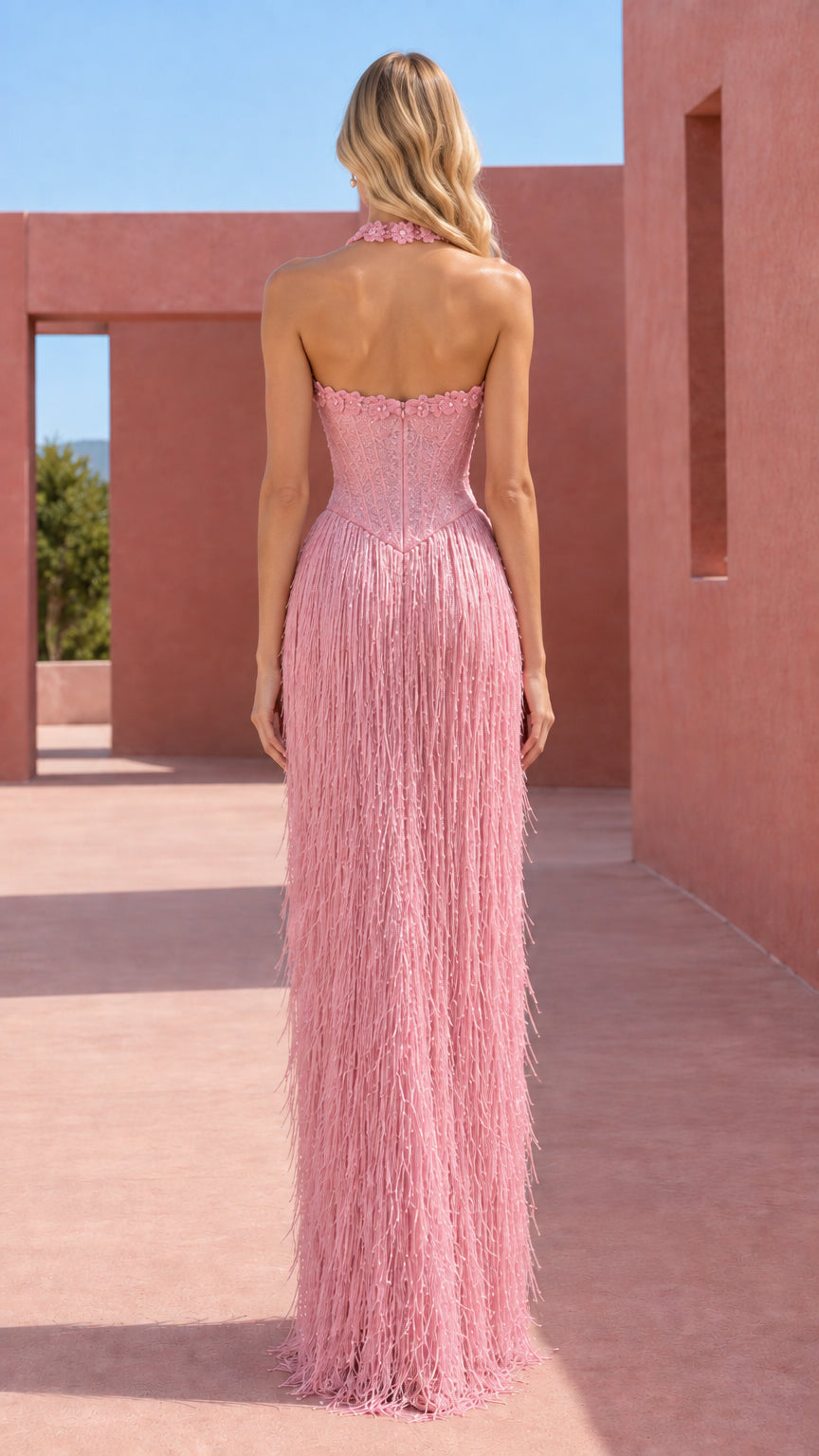 Back view of dusty pink halter evening gown featuring open back design and flowing fringe
