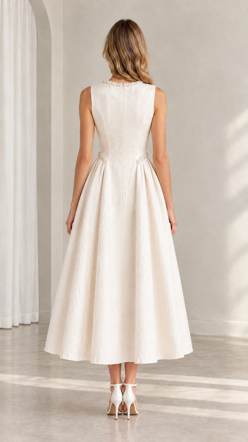 Back view of model wearing ivory sleeveless flared midi dress