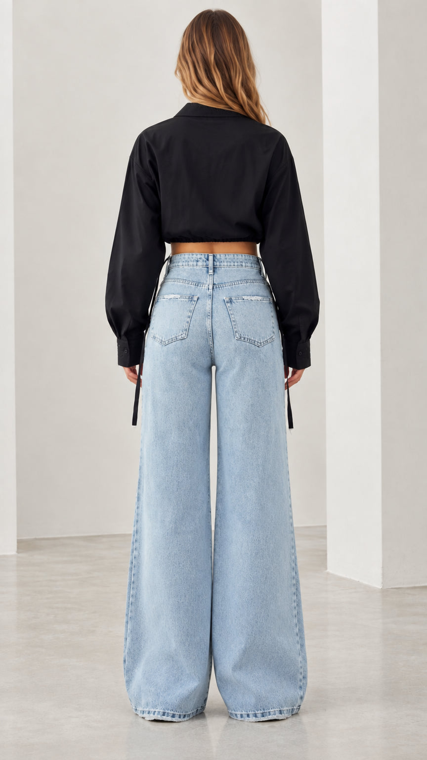 Back view of black long sleeve cropped shirt with wide leg denim