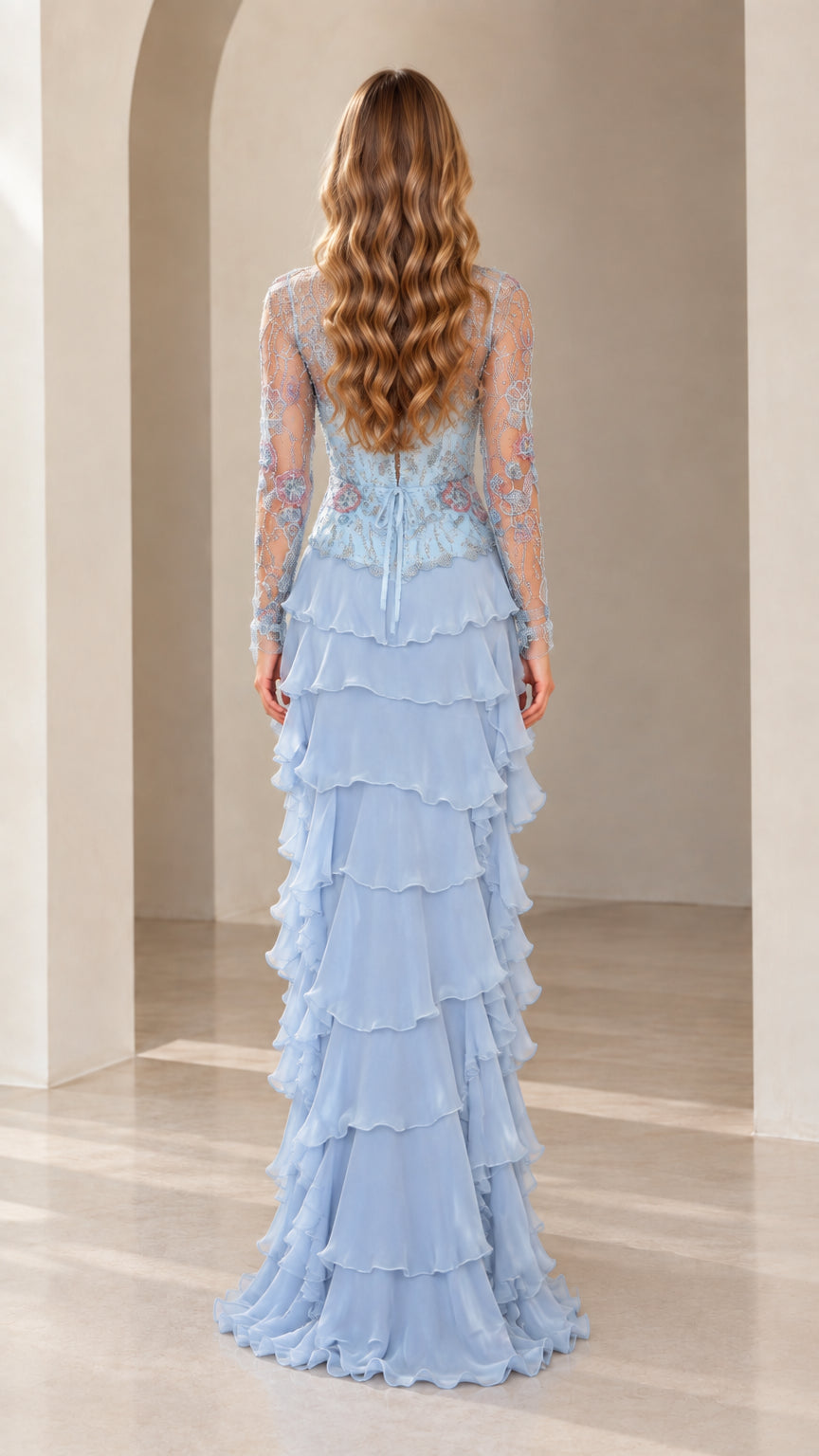 Back view of model in Sky Blue embroidered long sleeve evening gown with tiered skirt