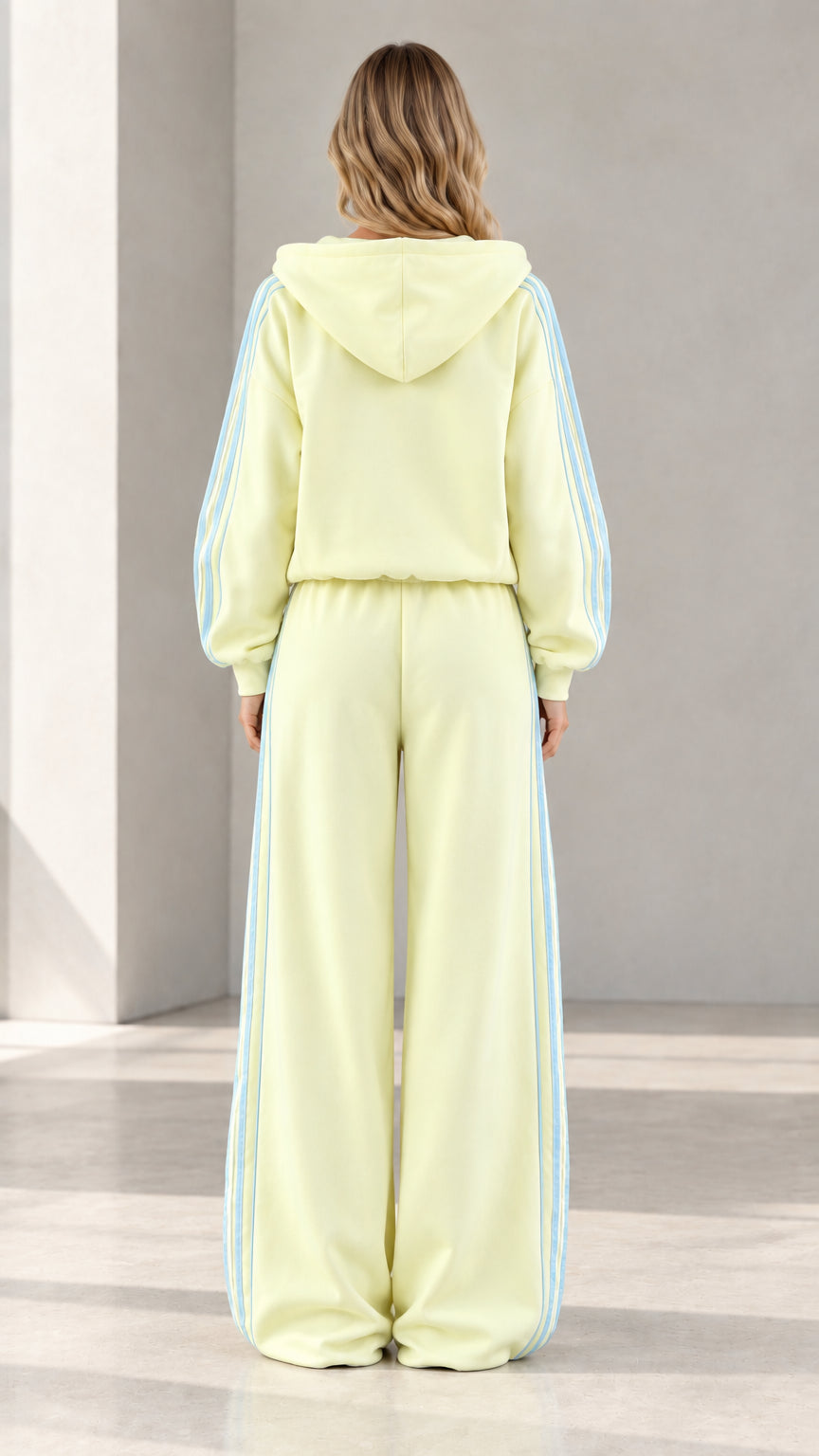 Back view of model wearing butter yellow hooded tracksuit set with wide-leg pants