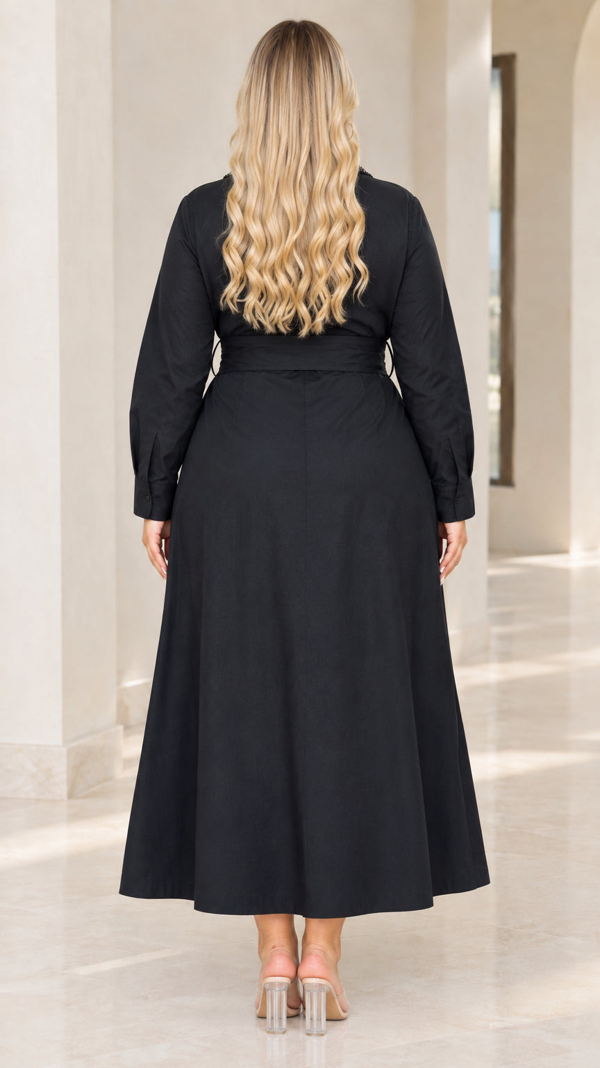 Back view of woman wearing flowing black maxi shirt dress with tie belt