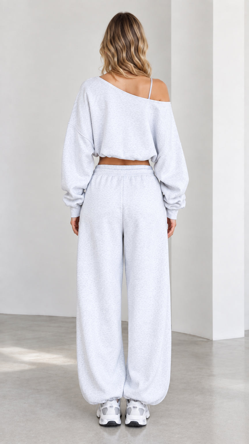 Back view of model wearing heather grey off-shoulder crop top and relaxed sweatpants