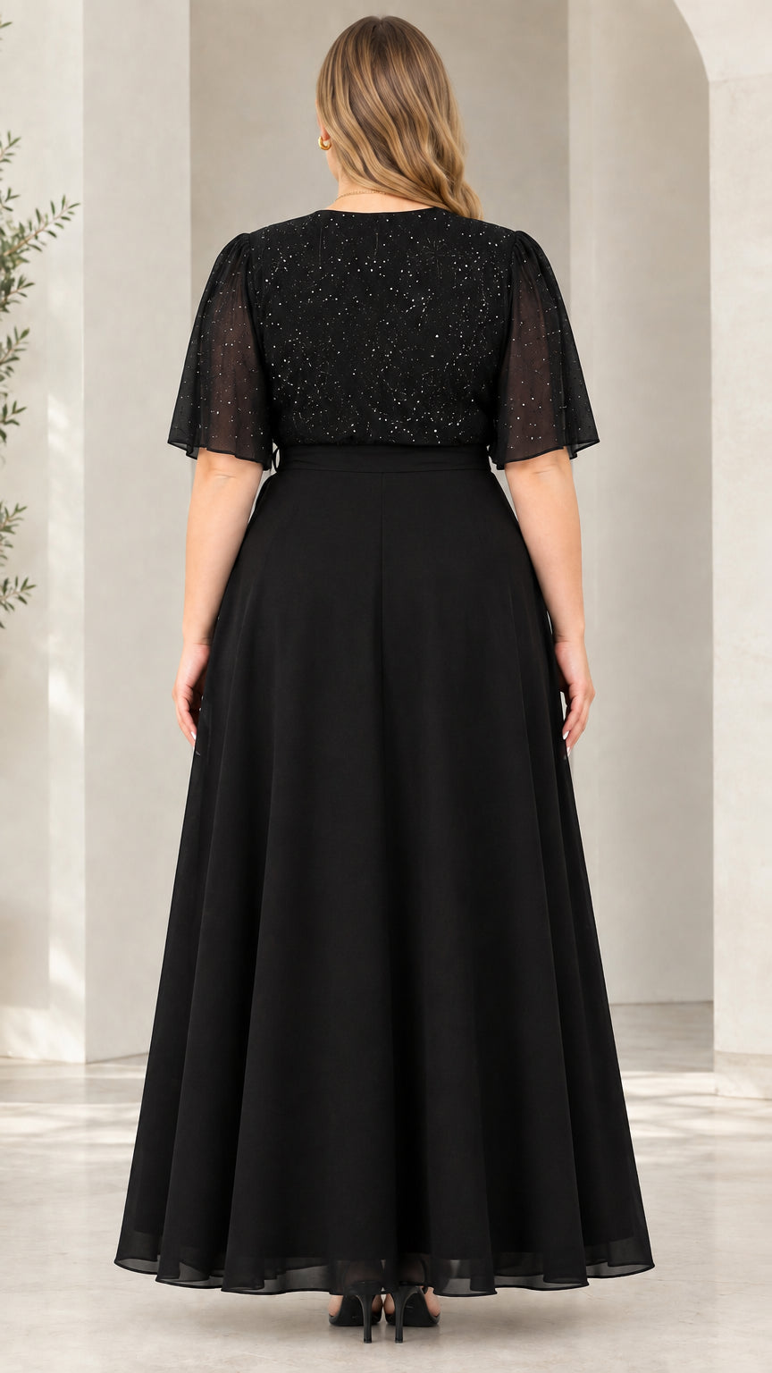 Back view of model wearing black chiffon evening maxi dress with tie waist